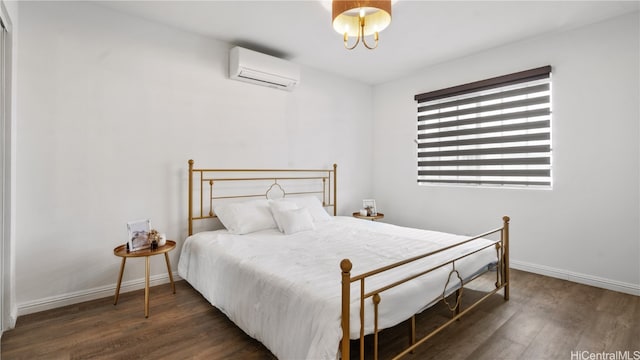 bedroom with a wall unit AC and dark hardwood / wood-style floors