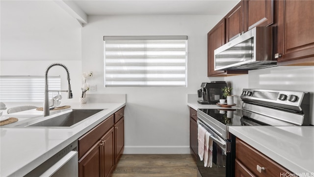 kitchen with stainless steel appliances, sink, and dark hardwood / wood-style floors