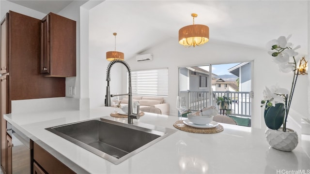 kitchen featuring vaulted ceiling, kitchen peninsula, sink, an AC wall unit, and decorative light fixtures