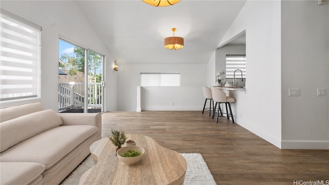 living room featuring dark wood-type flooring, sink, and vaulted ceiling