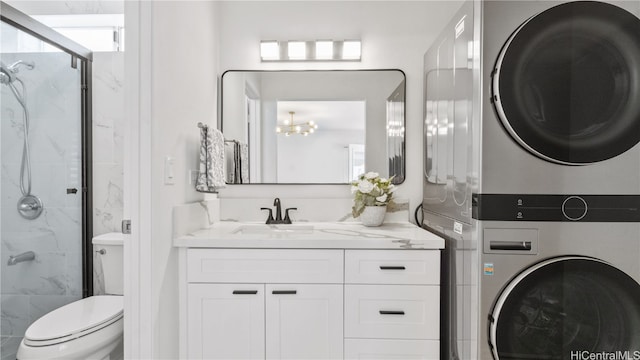 clothes washing area with stacked washer / drying machine, an inviting chandelier, and sink