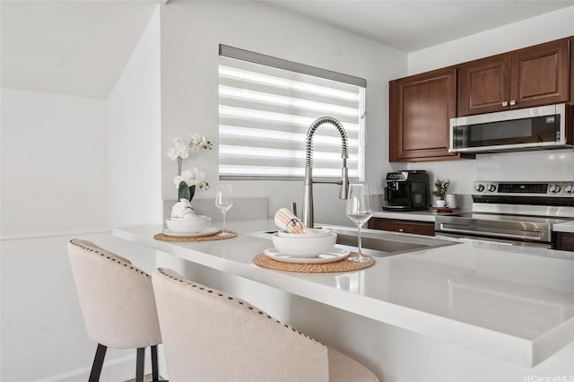 91-1030 Hoopili St Unit 54, Ewa Beach, HI 96706 - kitchen with appliances with stainless steel finishes, light countertops, and a kitchen bar
