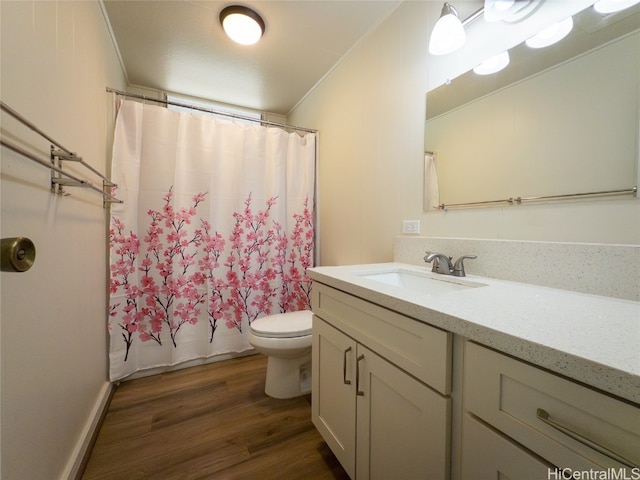 bathroom featuring wood-type flooring, toilet, vanity, crown molding, and curtained shower