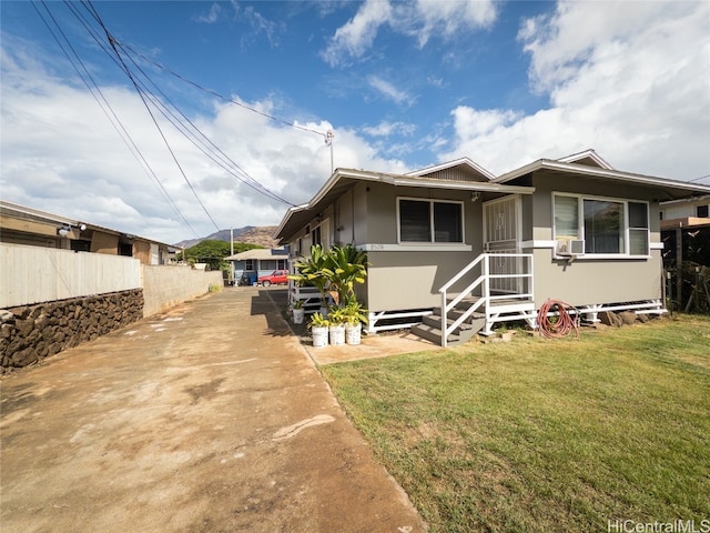 view of front facade with a front yard and cooling unit