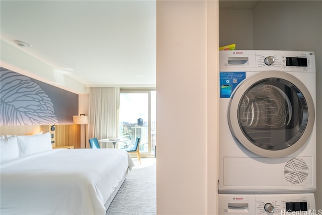 carpeted bedroom with stacked washer and clothes dryer