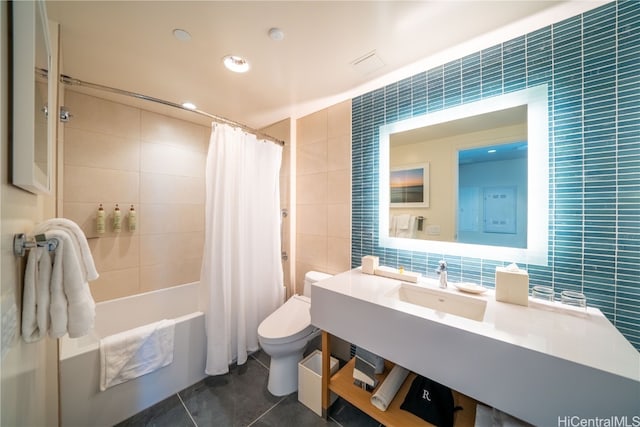 bathroom with toilet, shower / tub combo, tile patterned floors, and tile walls