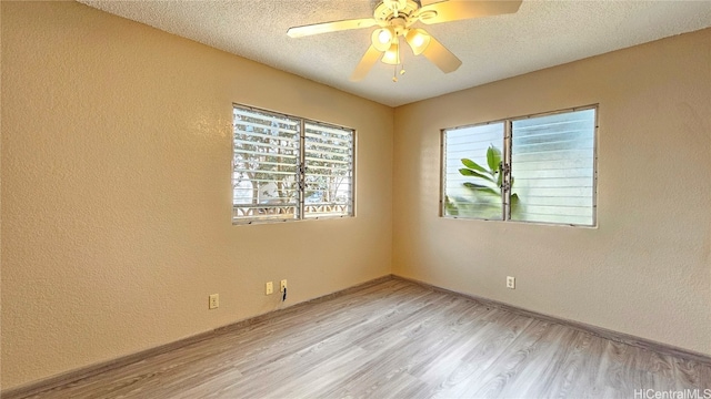 spare room featuring ceiling fan, light hardwood / wood-style floors, and a textured ceiling