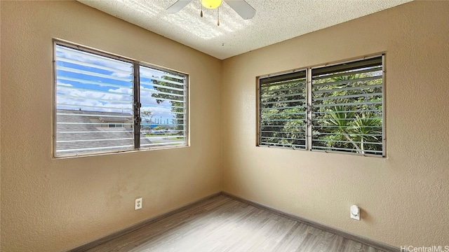 spare room with ceiling fan, wood-type flooring, and a textured ceiling