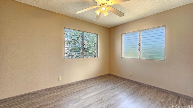 empty room featuring a textured ceiling, light hardwood / wood-style floors, and ceiling fan