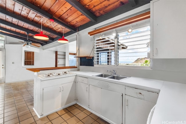 kitchen with wood ceiling, beam ceiling, sink, pendant lighting, and white cabinets