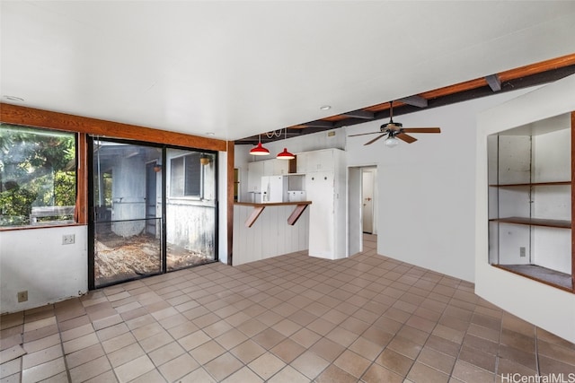 unfurnished living room with ceiling fan, beamed ceiling, and tile patterned flooring