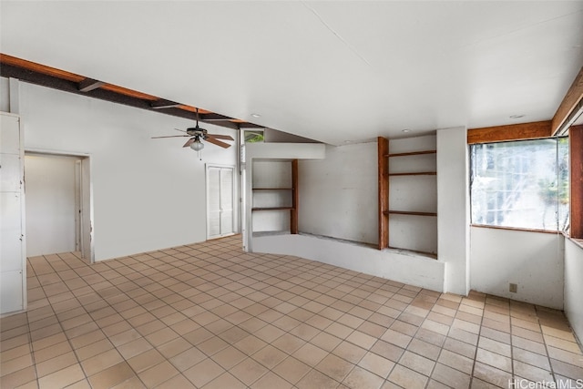 tiled spare room with vaulted ceiling and ceiling fan