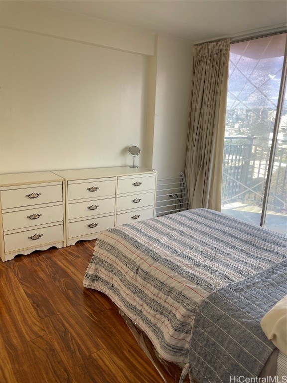 bedroom with access to outside and dark wood-type flooring