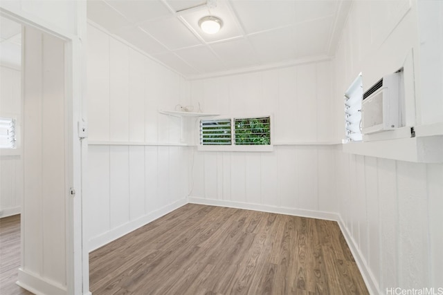 empty room with wood walls and hardwood / wood-style floors