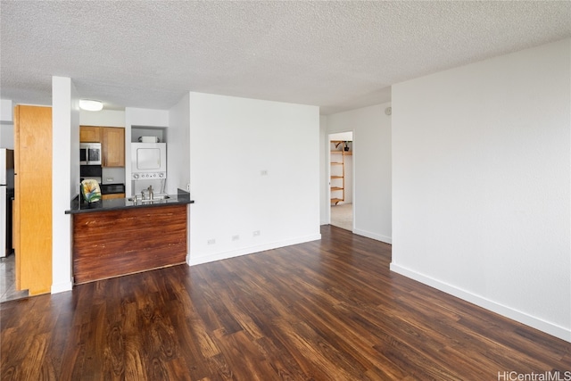 unfurnished living room featuring a textured ceiling and dark hardwood / wood-style flooring