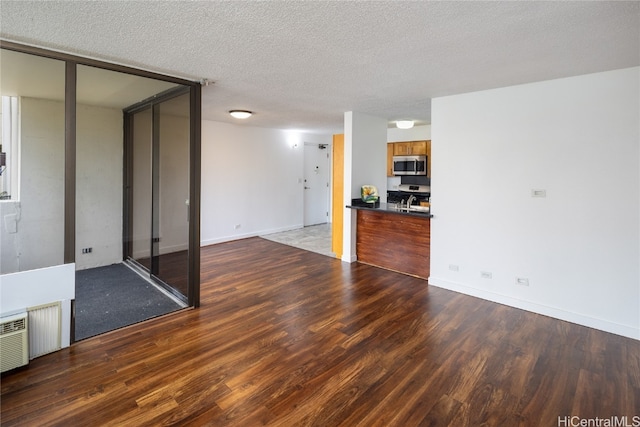 interior space with a textured ceiling and hardwood / wood-style flooring