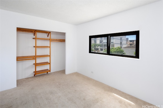 unfurnished bedroom featuring a closet, a textured ceiling, and carpet