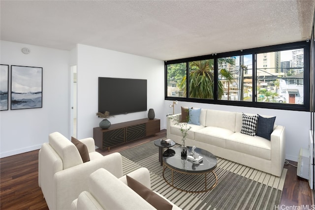 living room featuring dark wood-type flooring, a healthy amount of sunlight, a textured ceiling, and a wall of windows