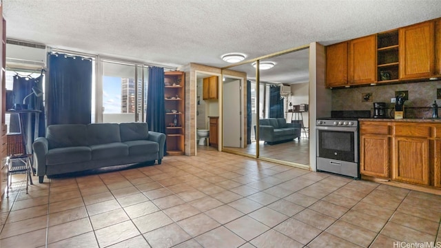 kitchen with tasteful backsplash, a textured ceiling, light tile patterned flooring, and stainless steel stove