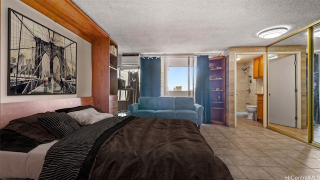 tiled bedroom featuring a wall mounted air conditioner and a textured ceiling