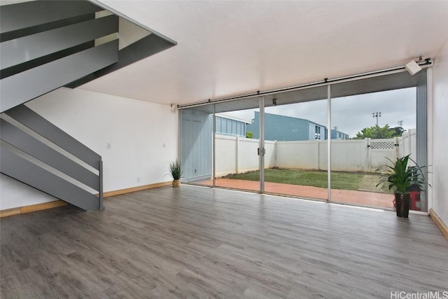 unfurnished living room with hardwood / wood-style floors and a wall of windows