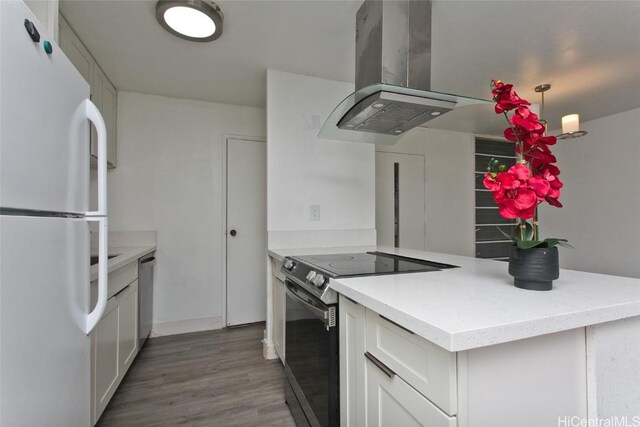 kitchen with appliances with stainless steel finishes, island range hood, pendant lighting, white cabinetry, and dark wood-type flooring