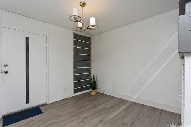 unfurnished dining area with hardwood / wood-style flooring and a chandelier