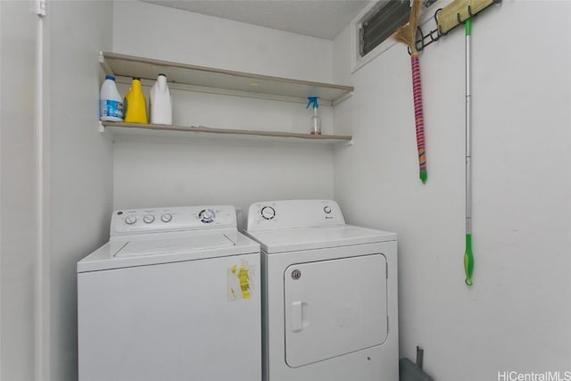 laundry area with washing machine and dryer and a textured ceiling