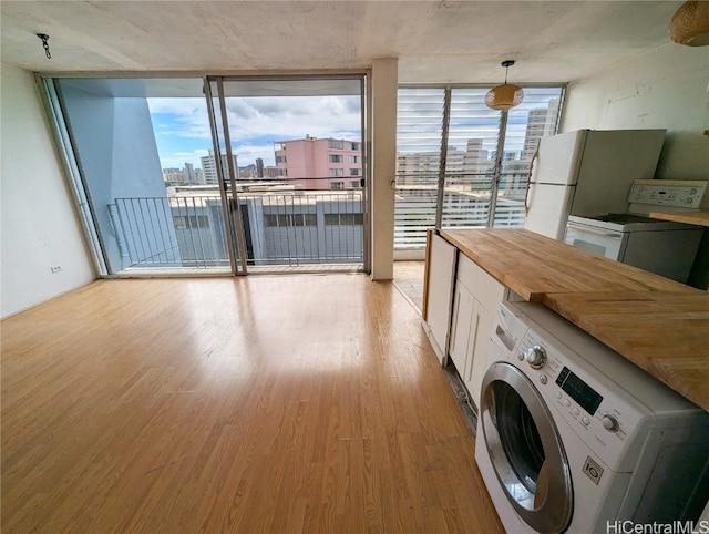 laundry room with washer / dryer and light hardwood / wood-style flooring