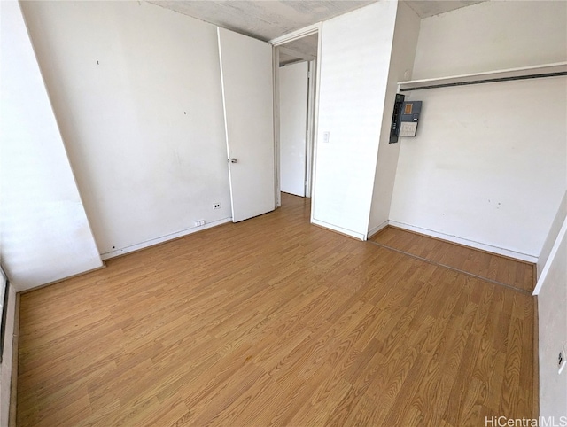 unfurnished bedroom with a closet and light wood-type flooring