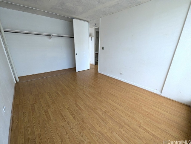 unfurnished bedroom with a closet and hardwood / wood-style floors