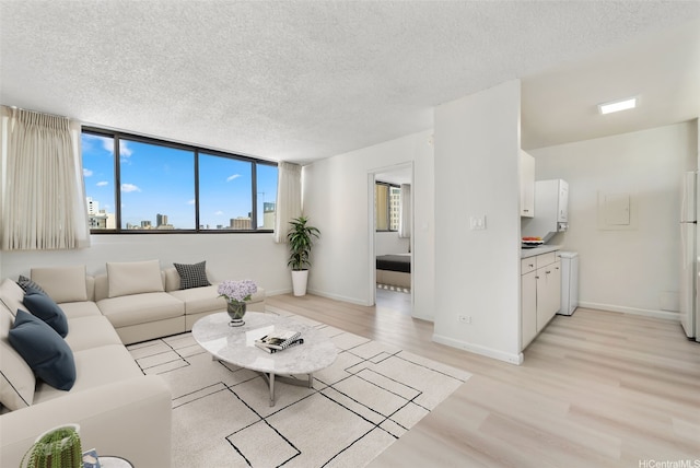 1040 Kinau St Unit 704, Honolulu, HI 96814 - living area featuring a textured ceiling, light wood-style floors, and baseboards