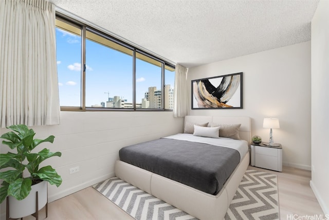 bedroom featuring light hardwood / wood-style floors and a textured ceiling