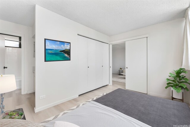 1040 Kinau St Unit 704, Honolulu, HI 96814 - bedroom with light wood-style floors, a textured ceiling, and a closet
