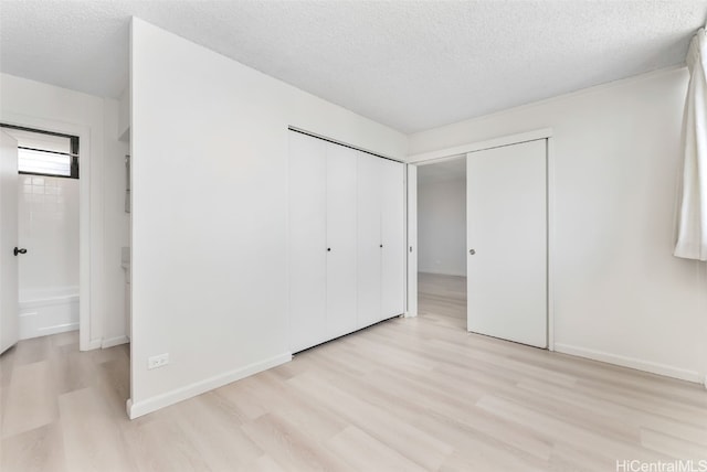 unfurnished bedroom featuring a textured ceiling and light wood-type flooring