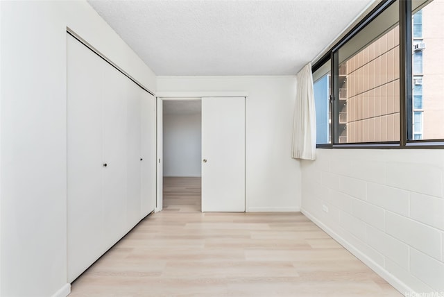 1040 Kinau St Unit 704, Honolulu, HI 96814 - unfurnished bedroom with light wood finished floors, a textured ceiling, and a closet
