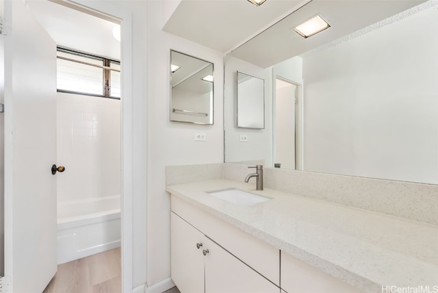 bathroom featuring vanity, wood-type flooring, and shower / bathtub combination