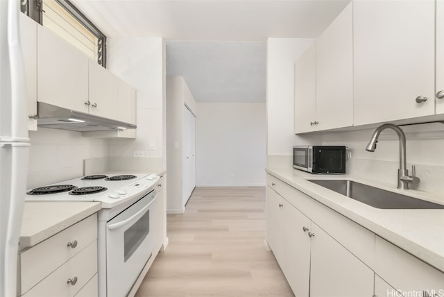 kitchen with white appliances, sink, light wood-type flooring, and white cabinets