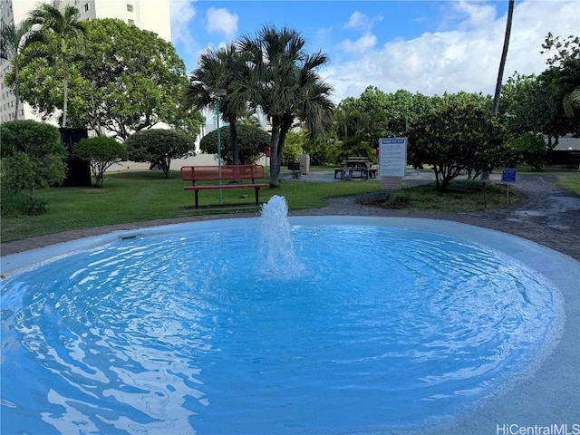 view of swimming pool with a yard