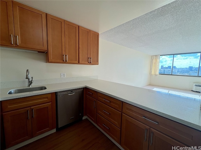 kitchen with stainless steel dishwasher, sink, dark wood-type flooring, and a textured ceiling