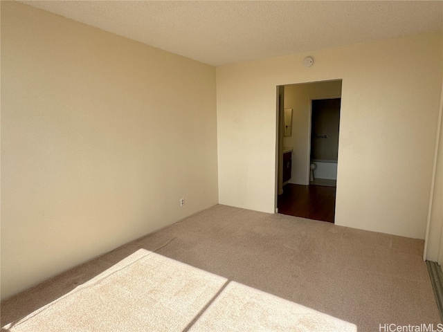 carpeted spare room with a textured ceiling