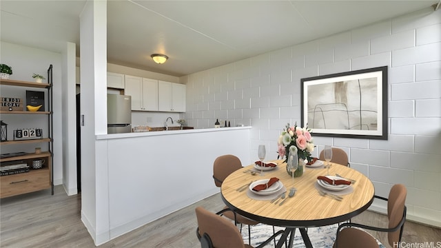 dining area with light hardwood / wood-style floors and sink