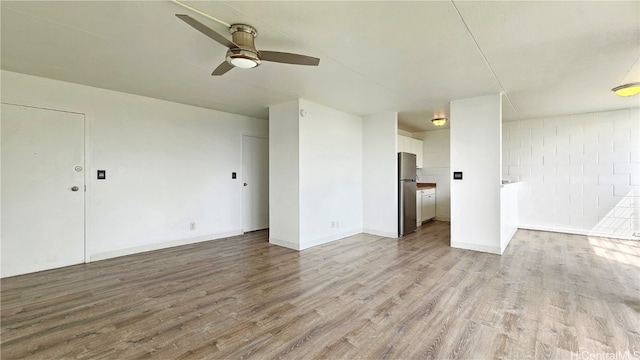 unfurnished room with light wood-type flooring and ceiling fan