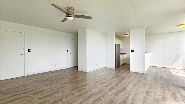 interior space with light wood-type flooring, baseboards, and a ceiling fan