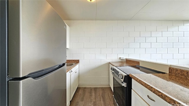 kitchen featuring white cabinetry, dark wood-type flooring, tile walls, and appliances with stainless steel finishes