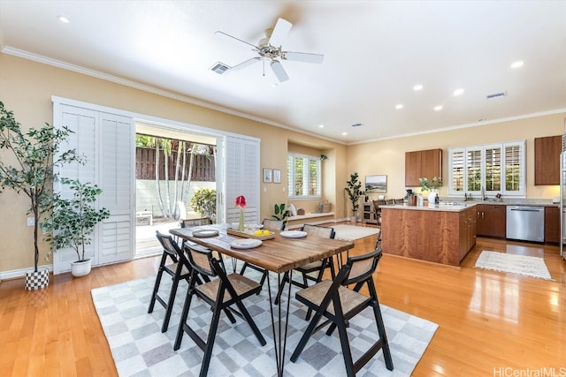 dining room with ornamental molding, light wood-type flooring, a healthy amount of sunlight, and ceiling fan