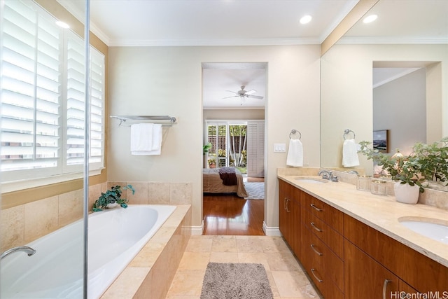 bathroom with vanity, crown molding, a relaxing tiled tub, and hardwood / wood-style floors