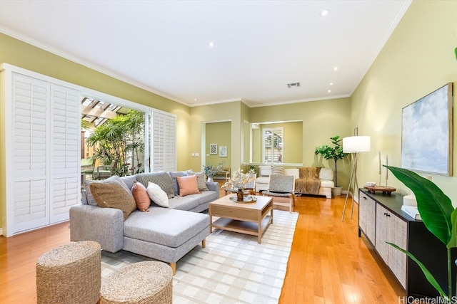 living room with light hardwood / wood-style floors and crown molding