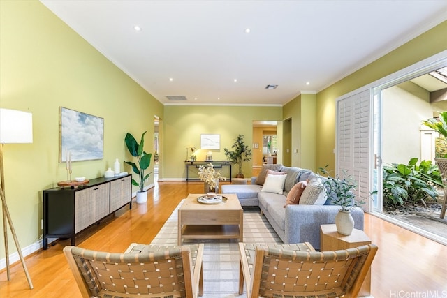 living room with light hardwood / wood-style floors and crown molding