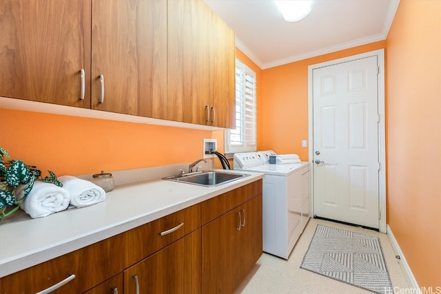 laundry area with ornamental molding, sink, washer and dryer, and cabinets